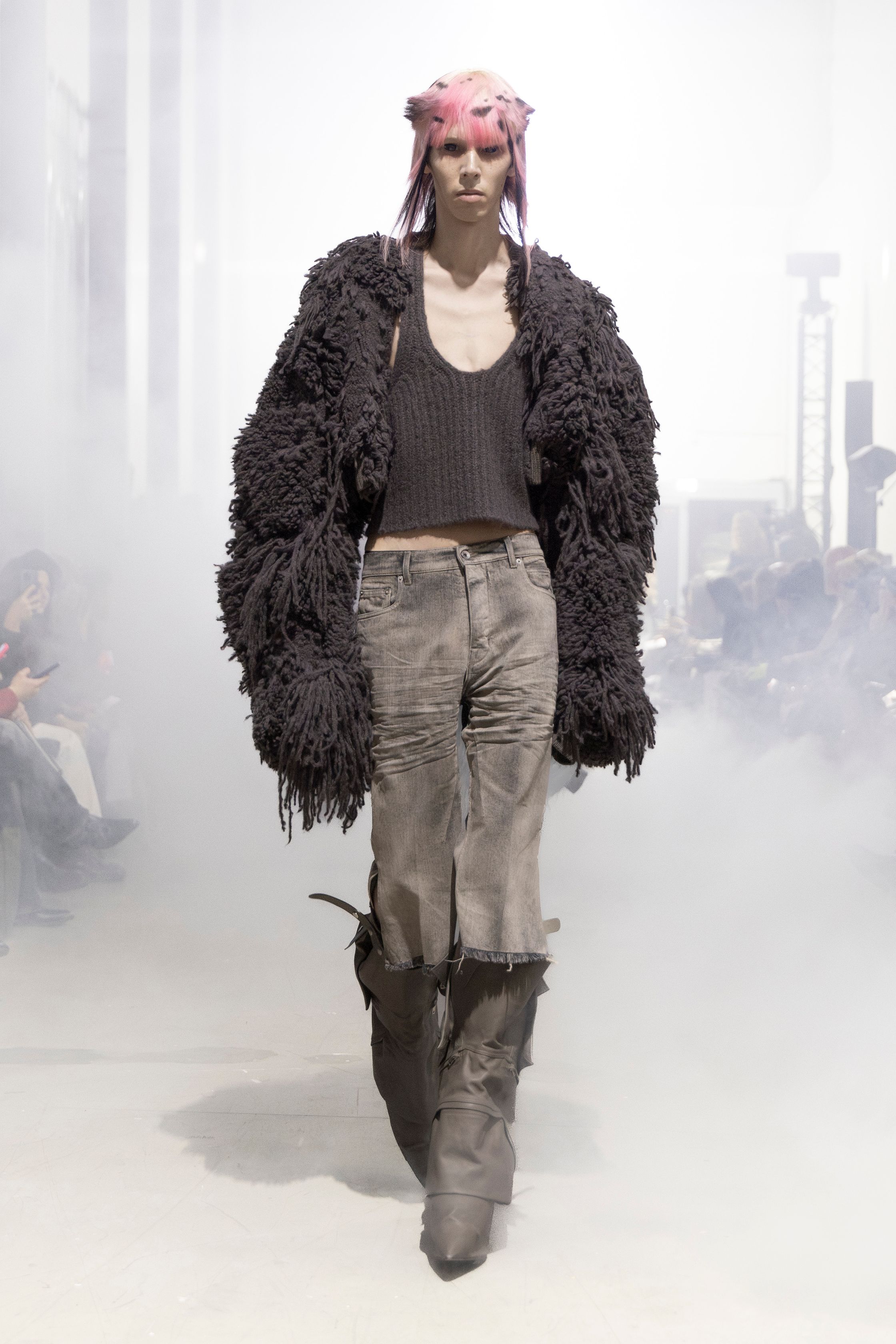 Rick Owens 2026秋冬延续其末世感与宗教式仪式美学。极端肩部结构、皮革与毛感材质在烟雾弥漫的空间中塑造出超越性别的强势身体。系列不再讨论日常，而是关于存在、力量与脆弱的对立统一。行走仿佛一种宣誓，服装成为精神铠甲，彰显Rick Owens一贯的黑暗崇高感-顽石频道趋势研究